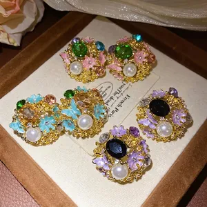Vintage baroque style floral stud earrings with enamel petals, rhinestones, and large pearls.