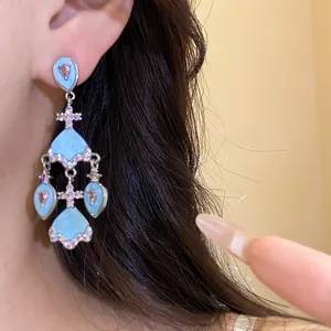 Détail des boucles d'oreilles vintage en acétate bleu clair avec zircons