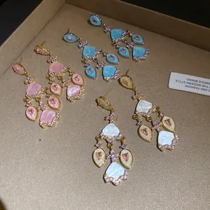 Gros plan de boucles d'oreilles vintage en zircon et acétate en rose, bleu et blanc