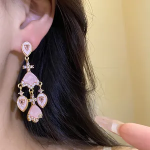 Vue détaillée des boucles d'oreilles vintage style palais avec acétate rose et zircons