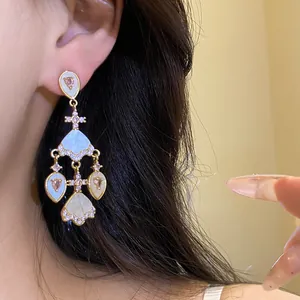 Gros plan sur des boucles d'oreilles chandelier vintage avec zircons roses et acétate.