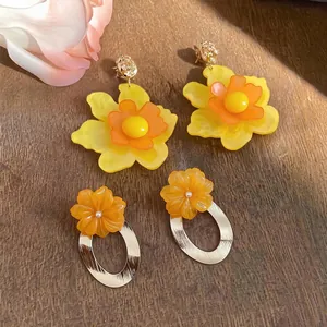 Stylish oversized yellow resin flower earrings and orange floral gold hoop dangles