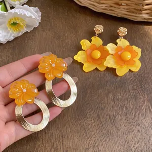 Elegant oversized orange and yellow resin flower drop earrings with golden metal finish