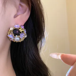 Detailed close-up of vintage floral pearl stud earring with purple gems worn on ear