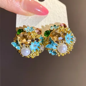 Macro detail of vintage enamel flower stud earrings with pearls and crystals