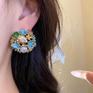 Detail shot of vintage palace style flower earrings with pearl and rhinestones on ear.