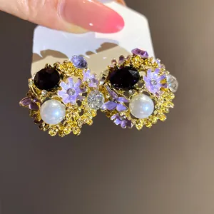 Detailed view of luxury vintage floral stud earrings with purple enamel and pearls
