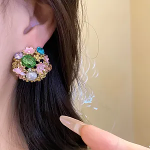 Close-up detail of a vintage palace-style earring featuring colorful stones and a pearl