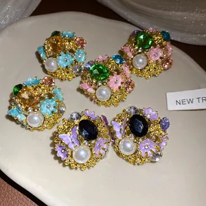 Detailed view of vintage palace style earrings with enamel flowers and faux pearls