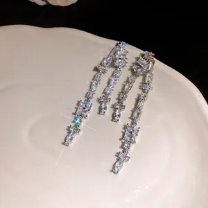 Detail view of long tassel earrings with sparkling cubic zirconia in marquise and square cuts