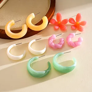 Detailed view of colorful resin earrings set featuring flower and hoop designs.