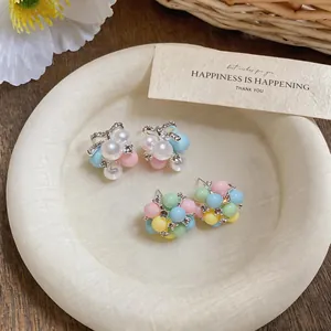 Detailed view of colorful macaron-style acrylic stud earrings in a pastel aesthetic