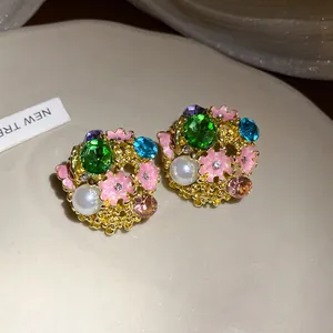 Close-up view of vintage floral stud earrings featuring vibrant crystals and pearls