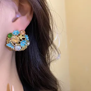 Close-up view of vintage floral stud earring featuring enamel petals and rhinestones