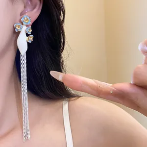 Gros plan de boucles d'oreilles vintage fleurs émaillées bleues et longues chaînes argent