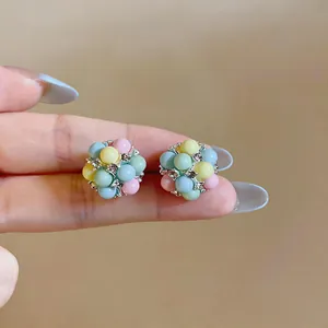 Macro detail of colorful dopamine macaron acrylic stud earrings with crystal accents