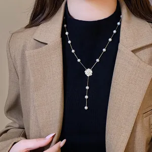 Zircon camellia flower pendant necklace with elegant pearls on a gold chain