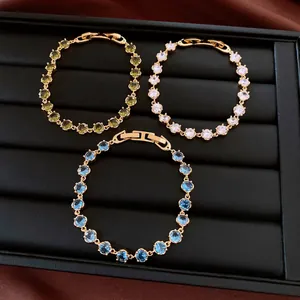 Nahaufnahme von 18k vergoldeten Armbändern mit runden Zirkonia in Blau, Grün und Weiß
