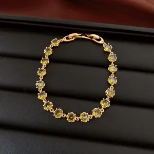 Detailansicht eines 18k vergoldeten Armbands mit runden olivgrünen Zirkoniasteinen.