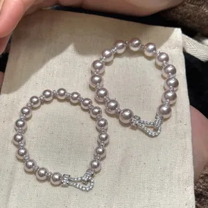 Elegant light pink pearl bracelet featuring a sparkling zircon horseshoe buckle clasp