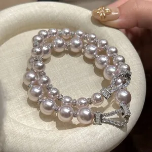 Elegant double-strand pink pearl bracelet featuring a sparkling CZ horseshoe clasp design