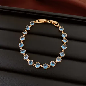 Detailansicht eines 18k vergoldeten Armbands mit blauen Zirkonia auf schwarzem Grund