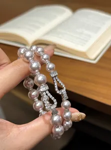 Macro view of an elegant pearl bracelet featuring a zircon-encrusted horseshoe buckle