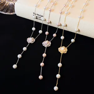 Close-up detail of camellia flower pearl necklaces with zircon accents on a book