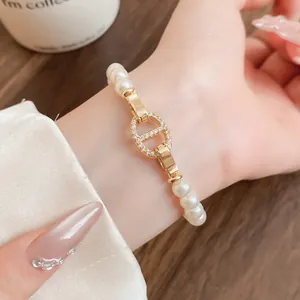 Detailansicht eines eleganten Perlenarmbands mit goldener Schweinenase-Schließe.