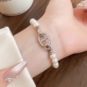 Detailansicht eines eleganten Perlenarmbands mit glitzerndem Schweinenasen-Glied