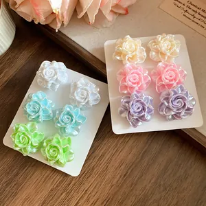 Set of six pearlescent resin rose stud earrings in pastel colors on white cards