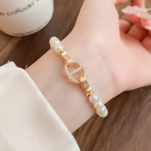 Nahaufnahme eines eleganten Perlenarmbands mit kristallbesetztem Schweinenasen-Anhänger