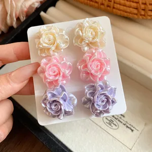 Macro view showing the glossy texture of six resin flower stud earrings in various colors