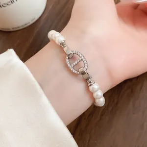 Detailaufnahme eines Vintage-Perlenarmbands mit kristallbesetztem Verschluss-Detail.