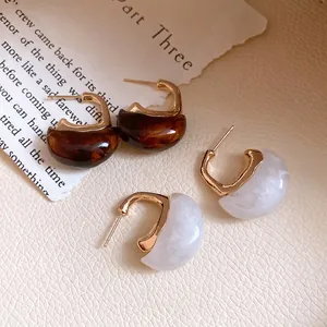 Vintage resin C-shaped hoop earrings in brown and white marbled patterns with gold accents