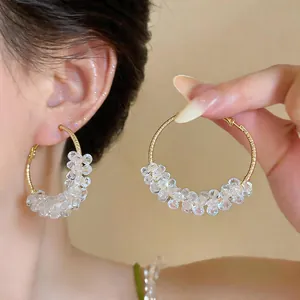 Detailansicht der klaren Glasperlen-Creolen mit Goldfinish im Dopamin-Stil für Damen.