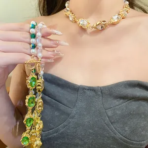 Exklusive Nahaufnahme einer Vintage-Perlenkette mit grünen Kristallen und Gold-Finish.