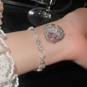 Primo piano di un lussuoso set composto da anello con zircone rosa e bracciale floreale di perle