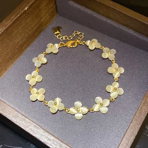 Detailed close-up of a French style flower bracelet with cat's eye stones in gold finish