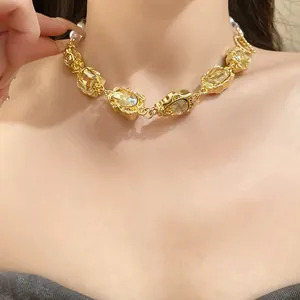 Nahaufnahme einer goldenen Vintage-Halskette mit Bernsteinkristallen und Perlen
