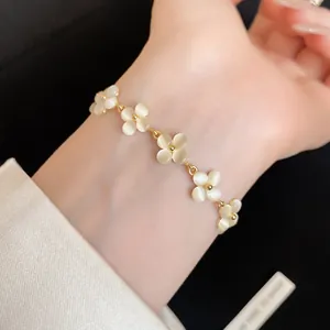 Close-up of a delicate French style cat's eye stone flower bracelet in gold-tone setting
