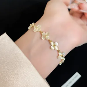 Detailed close-up of a French style cat eye stone flower bracelet on a female wrist