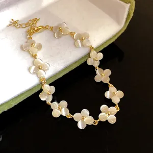 Close-up detail of elegant cat's eye stone flower bracelet with golden chain finish