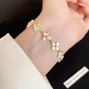 Exquisite detail shot of a delicate cat-eye stone flower bracelet on an elegant wrist