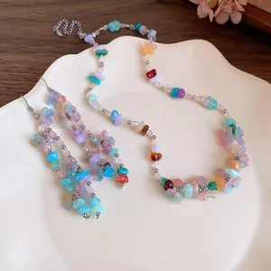 Detailed view of a colorful resin flower necklace and matching tassel earrings on a plate