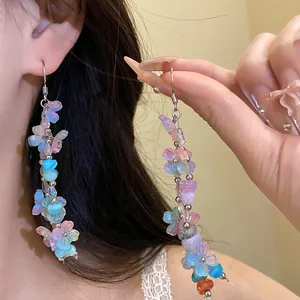 Detailed view of vibrant dopamine style resin flower tassel earrings shown on model