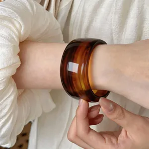 Primer plano de un brazalete ancho de acrílico con patrón de carey de estilo vintage