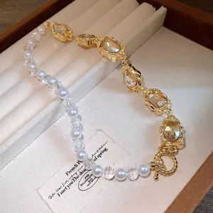Vintage Perlenkette mit goldfarbenen Kristallanhängern in einer luxuriösen Schmuckschatulle