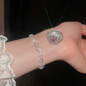 Set bracciale floreale in zircone e anello con pietra rosa, vista dettagliata indossata sulla mano.