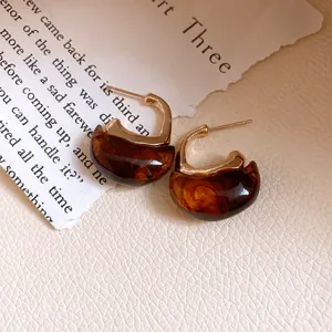 Retro C-shaped earrings with gold-toned metal and translucent amber resin texture